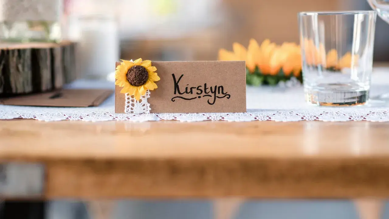 Urocza winietka z imieniem "Kirstyn" i słonecznikiem. Proste i stylowe, idealne, by pokazać, jak zrobić winietki na przyjęcie.