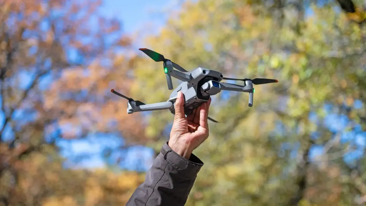 Dron w bagażu podręcznym Wizzair gotowy do lotu. Jesienne liście w tle.
