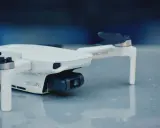 Biały dron Mavic Mini, ważący 249g, gotowy do rejestracji obrazu.