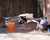 Biały dron Mavic Air w locie, z widocznymi śmigłami i kamerą.
