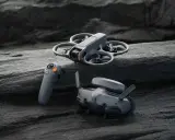 DJI Avata waga: dron, gogle i kontroler leżą na kamieniach.