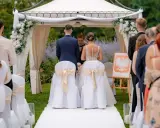 Para młoda podczas ceremonii ślubnej. Wesele w plenerze, pod namiotem ozdobionym kwiatami.