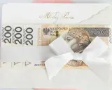 Biała koperta z napisem "Młodej Parze" i banknotami 200 zł. Zastanawiasz się, ile się daje na wesele? Oto inspiracja!