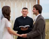 Para młoda trzyma się za ręce, a ksiądz błogosławi ich w dniu ślubu. Kiedy płaci się księdzu za ślub, ważne jest, by pamiętać o tej uroczystej chwili.