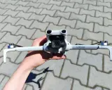Ręka trzyma najnowszy dron DJI, gotowy do lotu. Jego kompaktowa konstrukcja i zaawansowana kamera zapowiadają niesamowite ujęcia.