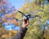 Dron w bagażu podręcznym Wizzair gotowy do lotu. Jesienne liście w tle.