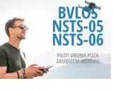 Mężczyzna steruje dronem poza zasięgiem wzroku. BVLOS co to? To pilotowanie dronów zgodnie z przepisami NSTS-05 i NSTS-06.