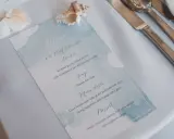Menu weselne z akwarelowym motywem morskim, ozdobione muszlami.