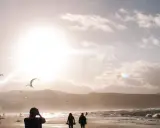 Zachód słońca na plaży, kitesurferzy w akcji. Idealna fotografia poradnik dla miłośników sportów wodnych i pięknych krajobrazów.