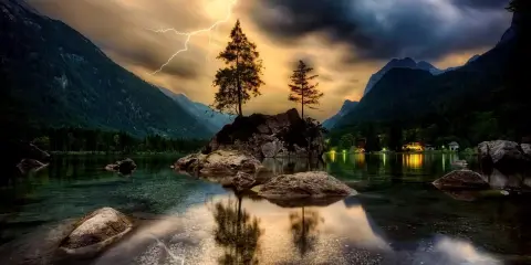 Dramatyczna burza nad jeziorem, błyskawica rozświetla niebo, a HDR w aparacie telefonu uchwycił piękno krajobrazu.