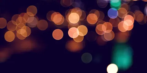 Rozmyte kółka świateł tworzą magiczny efekt bokeh w telefonie, przypominając nocne miasto.