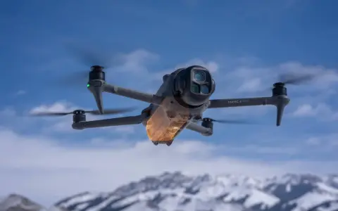 Mavic 4 Pro w locie, sterowany przez aplikację dji fly. W tle ośnieżone góry i błękitne niebo.