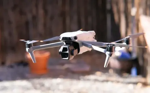 Biały dron Mavic Air w locie, z widocznymi śmigłami i kamerą.