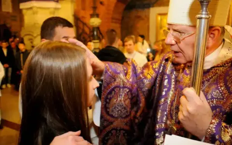 Biskup namaszcza młodą dziewczynę podczas bierzmowania. Czy bierzmowanie jest obowiązkowe? To ważny sakrament.