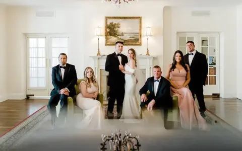 Para młoda z rodziną pozuje do zdjęcia przed ślubem. Eleganckie stroje i uroczysta atmosfera.