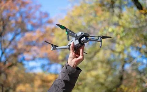 Dron w bagażu podręcznym Wizzair gotowy do lotu. Jesienne liście w tle.