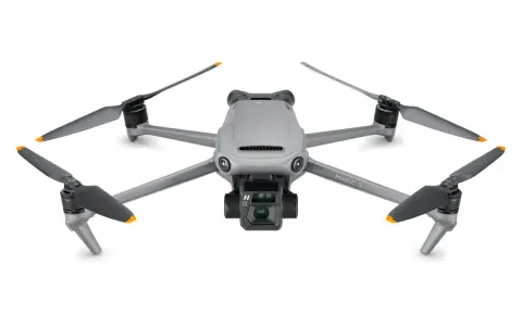 Szary dron DJI Mavic 3 z kamerą i czterema śmigłami. Jego niewielka waga pozwala na długie loty.
