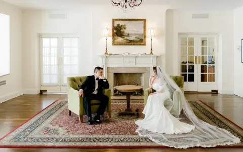 Para młoda siedzi naprzeciwko siebie w eleganckich fotelach. Widać, co daje ślub: spokój i wzajemne spojrzenie.