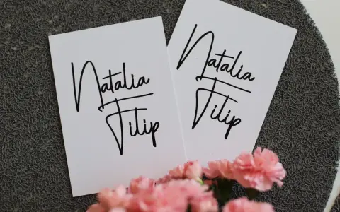 Dwie białe kartki z napisem "Natalia Filip" - idealne, by dowiedzieć się, jak wypisać zaproszenie dla cioci i wujka.