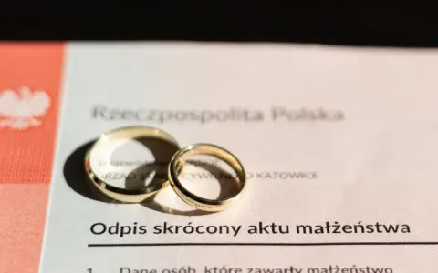 Złote obrączki na odpisie skróconym aktu małżeństwa po ślubie cywilnym.