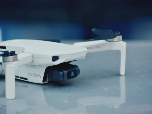 Biały dron Mavic Mini, ważący 249g, gotowy do rejestracji obrazu.