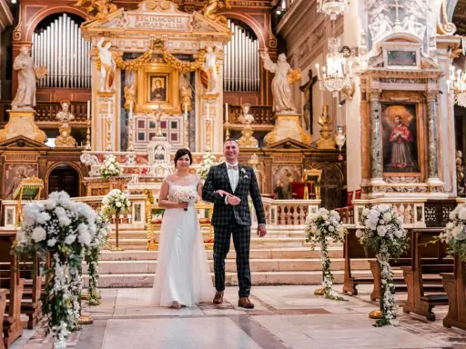 Para młoda idzie do ołtarza podczas ślubu w Rzymie. Wspaniała bazylika, ozdobiona kwiatami i organami, tworzy magiczną atmosferę.