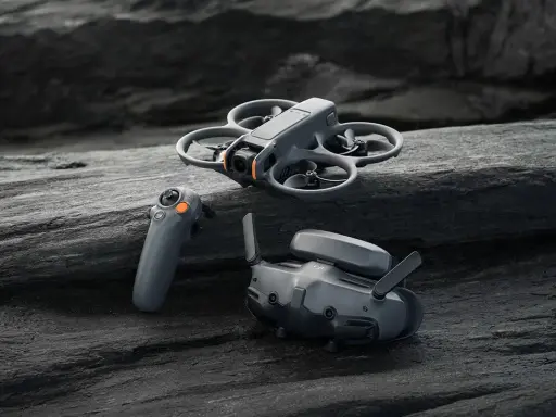 DJI Avata waga: dron, gogle i kontroler leżą na kamieniach.