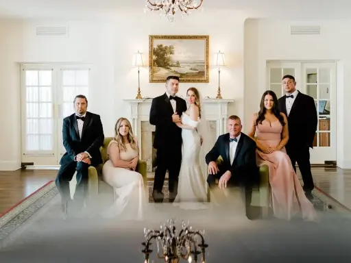 Para młoda z rodziną pozuje do zdjęcia przed ślubem. Eleganckie stroje i uroczysta atmosfera.