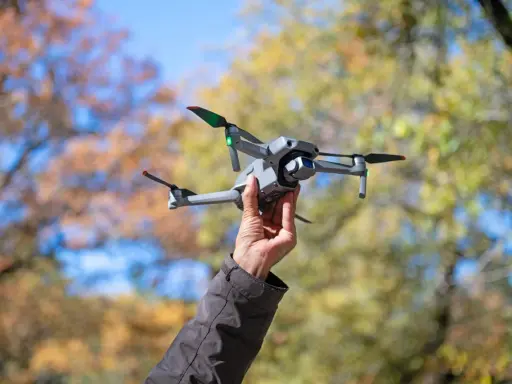 Dron w bagażu podręcznym Wizzair gotowy do lotu. Jesienne liście w tle.