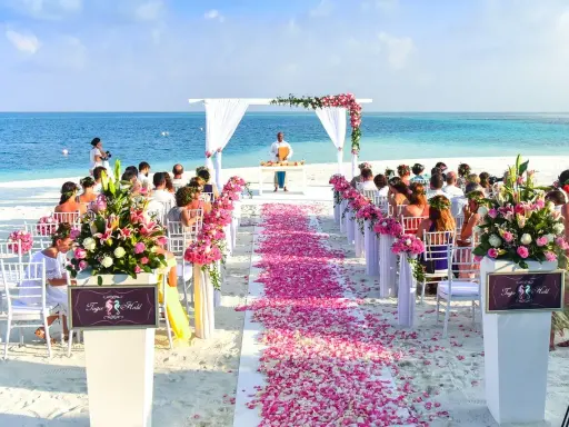 Plażowa ceremonia ślubna z różowymi płatkami kwiatów. Marzenie o najpiękniejsze miejsca na ślub w Polsce staje się rzeczywistością.
