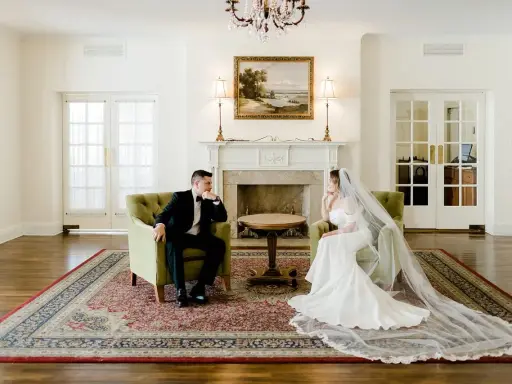 Para młoda siedzi naprzeciwko siebie w eleganckich fotelach. Widać, co daje ślub: spokój i wzajemne spojrzenie.
