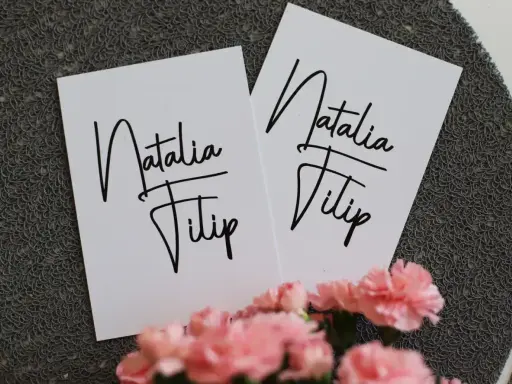 Dwie białe kartki z napisem "Natalia Filip" - idealne, by dowiedzieć się, jak wypisać zaproszenie dla cioci i wujka.