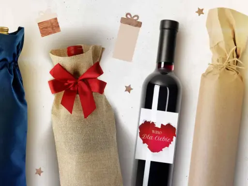 Elegancka dekoracja butelki z winem na ślub. Wino w ozdobnym woreczku z juty, butelka z etykietą "Wino dla Ciebie" i butelka owinięta w papier.