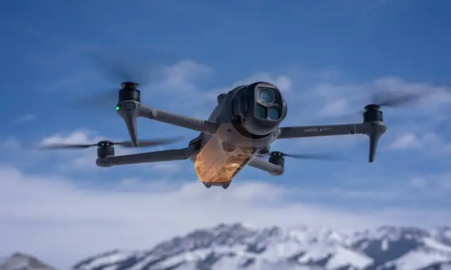 Mavic 4 Pro w locie, sterowany przez aplikację dji fly. W tle ośnieżone góry i błękitne niebo.