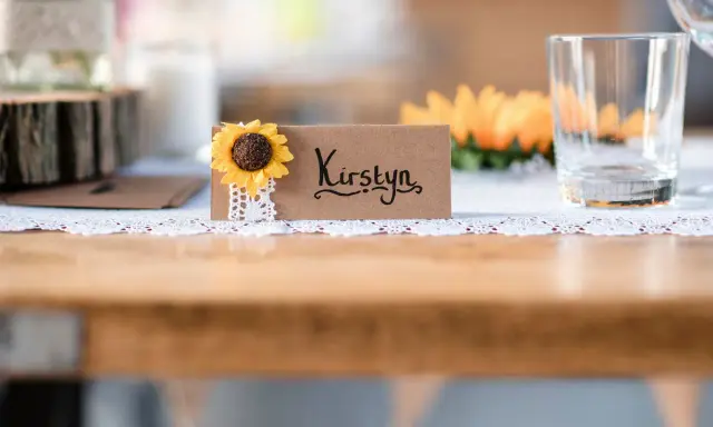 Urocza winietka z imieniem "Kirstyn" i słonecznikiem. Proste i stylowe, idealne, by pokazać, jak zrobić winietki na przyjęcie.