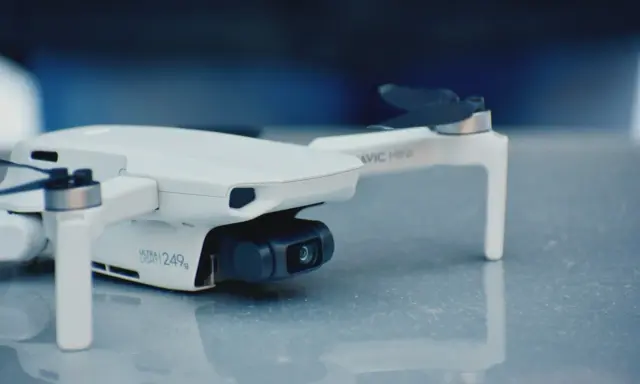 Biały dron Mavic Mini, ważący 249g, gotowy do rejestracji obrazu.
