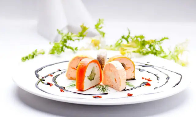 Eleganckie rolady rybne z warzywami, ozdobione sosem balsamicznym. Idealne na menu weselne z godzinami.