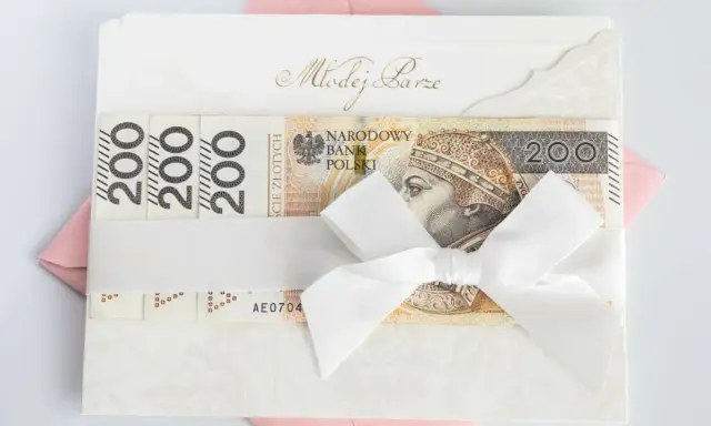 Biała koperta z napisem "Młodej Parze" i banknotami 200 zł. Zastanawiasz się, ile się daje na wesele? Oto inspiracja!