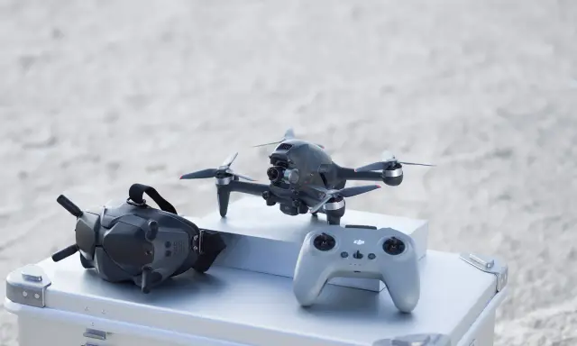 Szybkie drony, gogle FPV i kontroler gotowe do akcji na plaży.