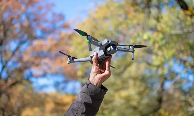 Dron w bagażu podręcznym Wizzair gotowy do lotu. Jesienne liście w tle.