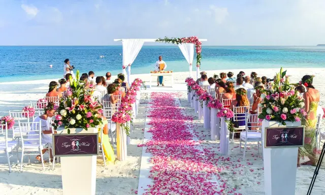 Plażowa ceremonia ślubna z różowymi płatkami kwiatów. Marzenie o najpiękniejsze miejsca na ślub w Polsce staje się rzeczywistością.