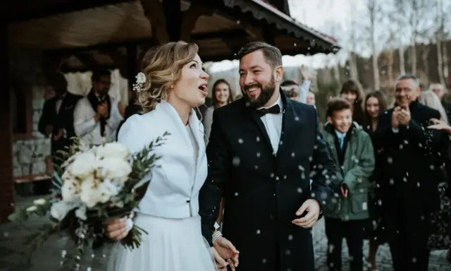 Szczęśliwa para młoda, trzymająca bukiet, wychodzi na zewnątrz podczas swojego ślubu w Adwencie. Sypią się na nich płatki.