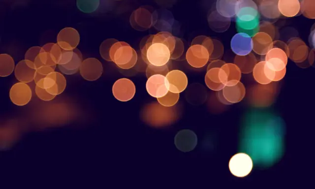 Rozmyte kółka świateł tworzą magiczny efekt bokeh w telefonie, przypominając nocne miasto.