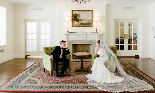 Para młoda siedzi naprzeciwko siebie w eleganckich fotelach. Widać, co daje ślub: spokój i wzajemne spojrzenie.