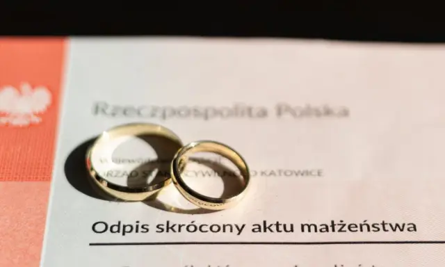 Złote obrączki na odpisie skróconym aktu małżeństwa po ślubie cywilnym.