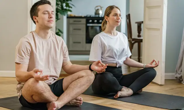 Para radzi sobie ze stresem przed ślubem, medytując razem w domu.