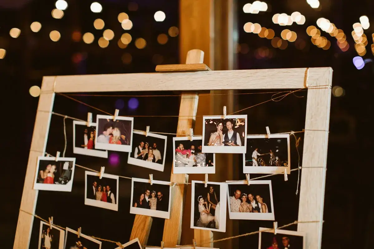Ramka z polaroidami z wesela, idealne pomysły na wesele niespodzianki. W tle migoczące światła.