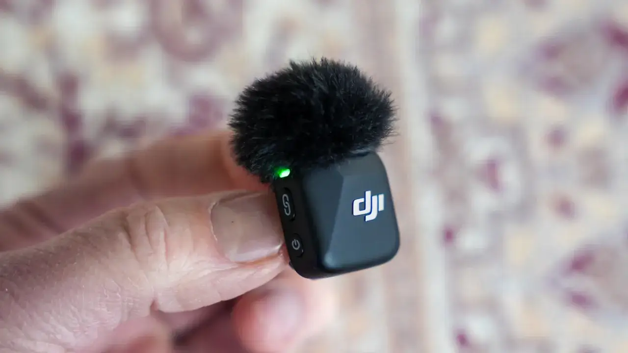 Mały mikrofon DJI z futerkiem, idealny do nagrywania dźwięku z dji mini 2. Zielona dioda sygnalizuje gotowość.