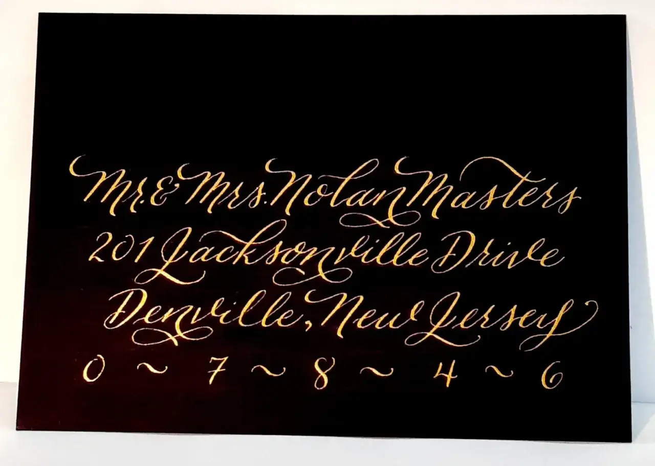 Eleganckie kaligraficzne pismo pokazuje, jak ładnie podpisać kopertę: Mr. & Mrs. Nolan Masters, 201 Jacksonville Drive, Denville, New Jersey 07846.