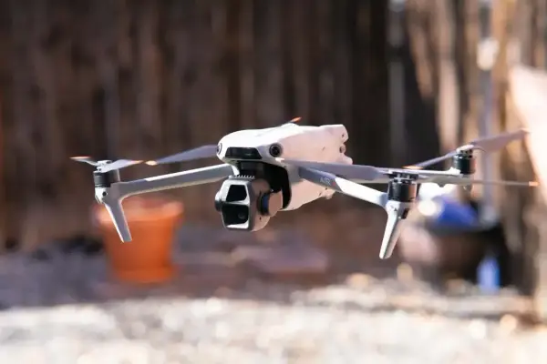 Biały dron Mavic Air w locie, z widocznymi śmigłami i kamerą.